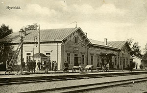 Vanha kuva Hyvinkään asemasta. Asemalla hevoskärryt odottamassa matkustajia, taustalla asemarakennus